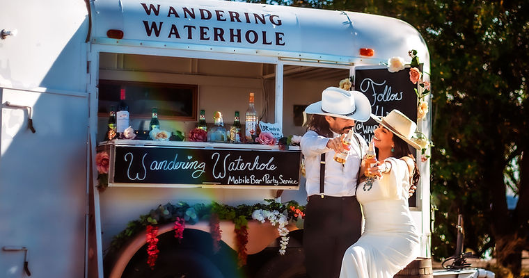 A man and a woman standing in front of a food truck