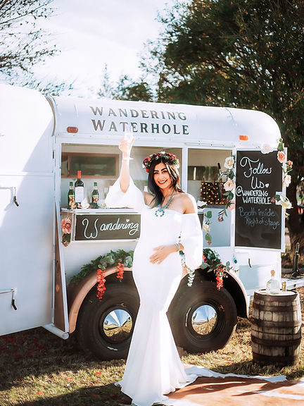 A woman in a white dress standing in front of a food truck