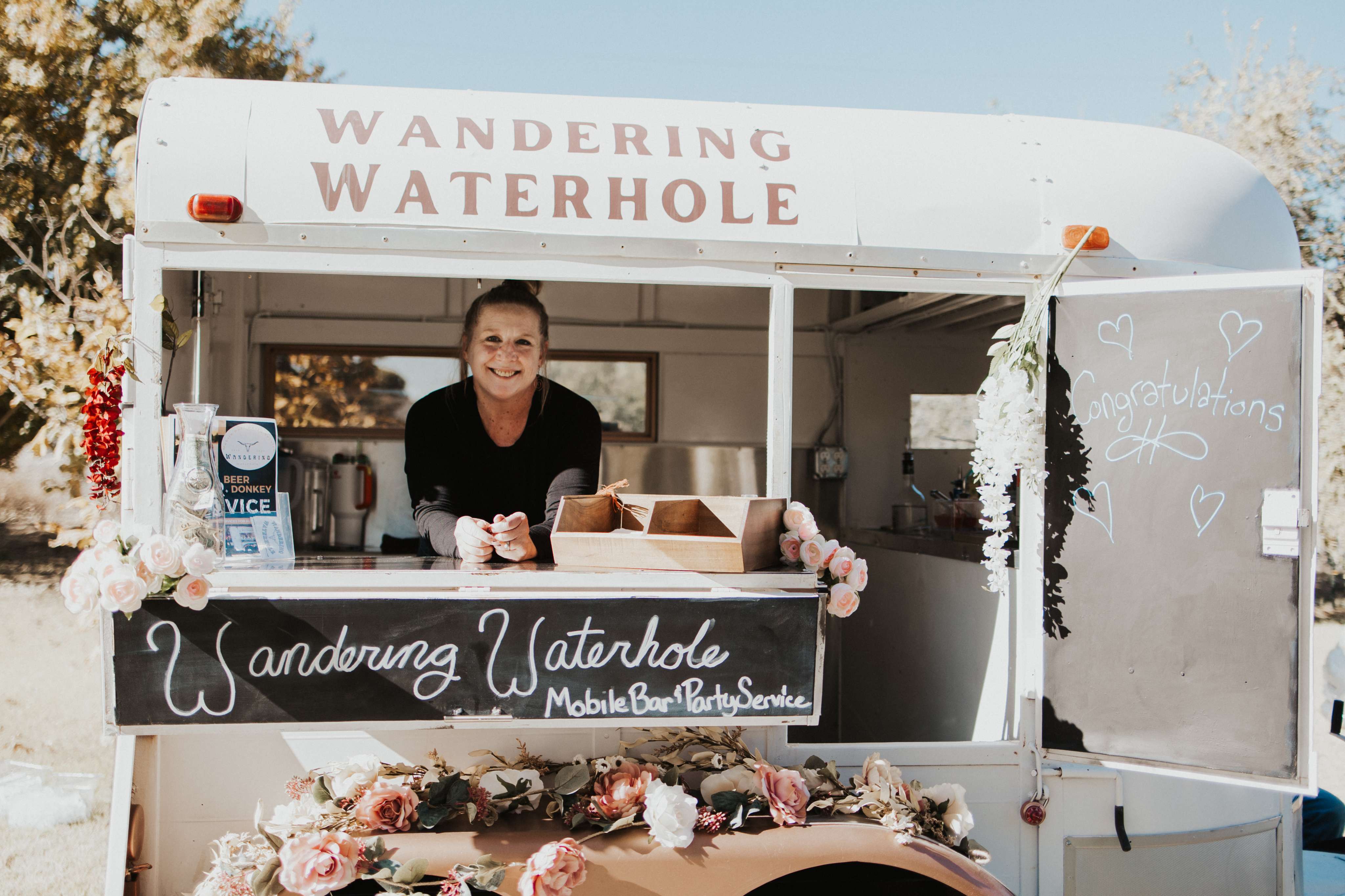 A woman standing behind a food truck selling food