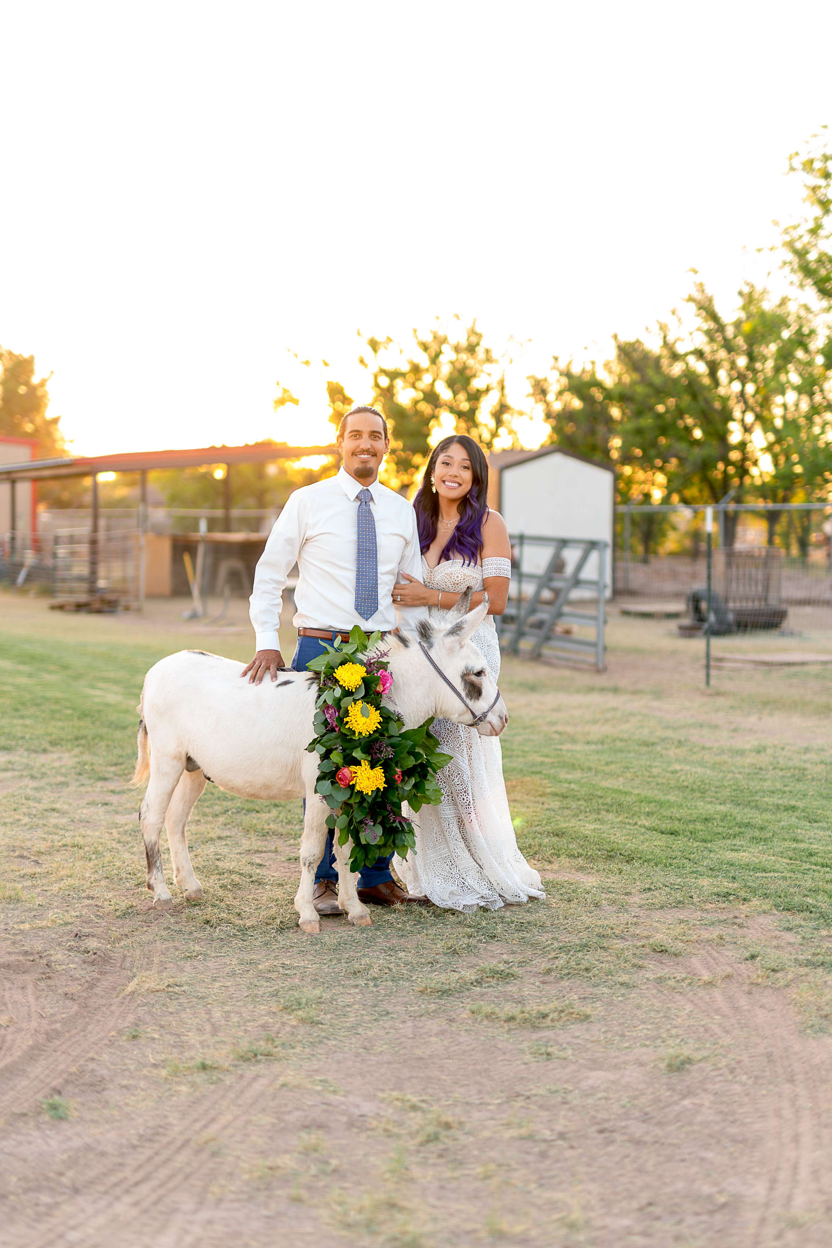 A man and woman standing next to a white horse